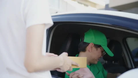 Asian delivery man send a package to customer on the cargo car. Stock Footage 213590886