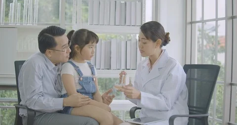 Asian dentist explaining to child about dental health education with jaw model Video stock 101409881