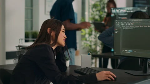 Asian developer coding html script information on computer at desk Stock Footage 231449709