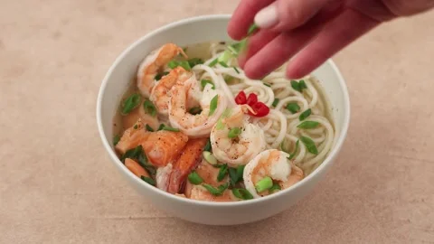 Asian dish with broth, noodles, tiger shrimp, fish and green onions. Stock Footage 288111480