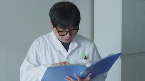 Asian doctor looking at chart / folder 2 Stock Footage 260363503