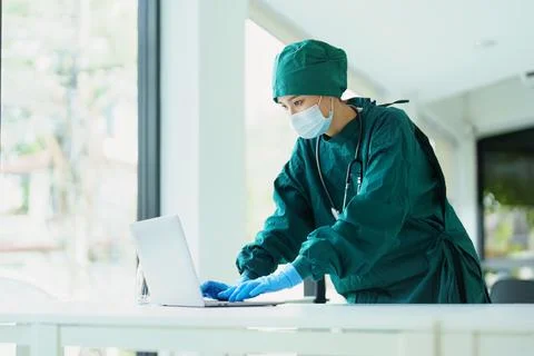 Asian doctor using a computer to look at patient information. Stock Photos