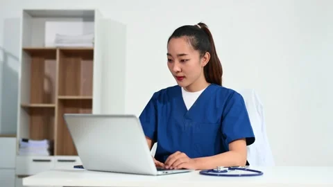 Asian doctor using tablet and laptop in medical office. Concept of healthca.. Stock Footage 312774215