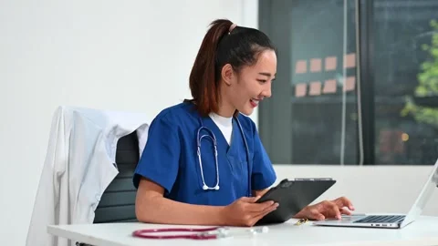 Asian doctor using tablet and laptop in medical office. Concept of healthca.. Stock Footage 312774237