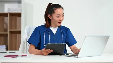 Asian doctor using tablet and laptop in medical office. Concept of healthca.. Stock Footage 312774239