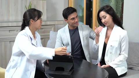 Asian doctor using tablet discussing with couple patients . Husband comfort.. Stock Footage 252953315