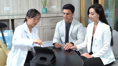 Asian doctor using tablet discussing with couple patients . Husband comfort.. Stock Footage 252965660