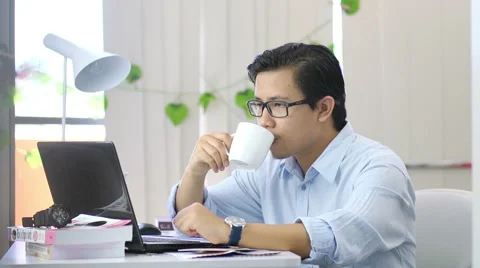 Asian Drinking Coffee at Work - Slow Motion Stock Footage 60606235
