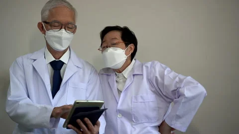 Asian elder doctors using tablet to customise hospital personal information Stock Footage 159421564