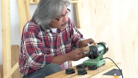 Asian elderly carpenter focus on his work in carpentry shop, small business.. Stock Footage 243189672
