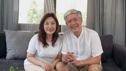 Asian elderly couple using smartphone video conference with grandchild at home. Stock Footage 111290198