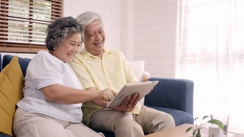 Asian elderly couple using tablet search medicine information in living room. Stock Footage 104773096