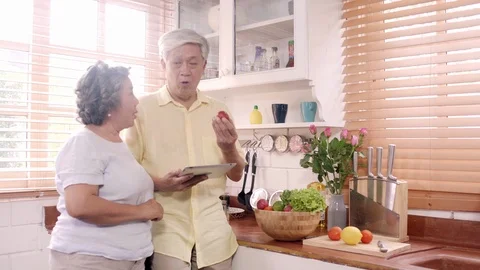 Asian elderly couple using tablet prepare ingredient in the kitchen. Stock Footage 104775623