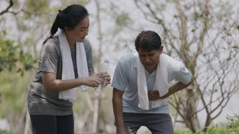 Asian Elderly couple workout jogging in village garden. Chest pain men Stock Footage 153422881