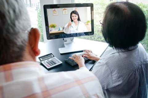 Asian elderly couples using computers Online video calling Talk to the doctor Stock Photos