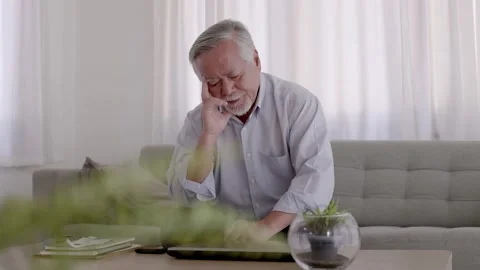 Asian Elderly have a headache. On the sofa in the living room Stock Footage 153784340