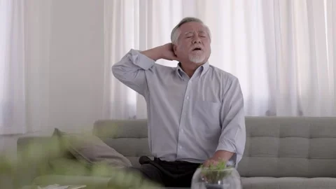 Asian Elderly have a headache. On the sofa in the living room Stock Footage 153784532