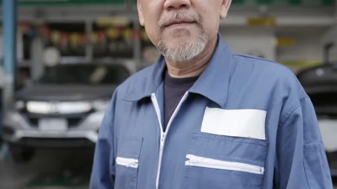 Asian elderly man are car mechanic Wear uniform, stand smiling, happy in service Vidéo 144999574