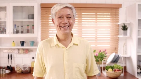 Asian elderly man feeling happy smiling while relax in kitchen at home. Stock Footage 104982938