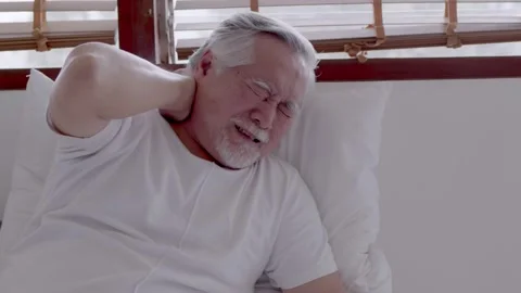 Asian Elderly man with a headache sitting on a bed in morning Stock Footage 153257266