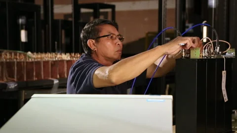 Asian electrical engineer with wrench testing computer component Stock Footage 139071854