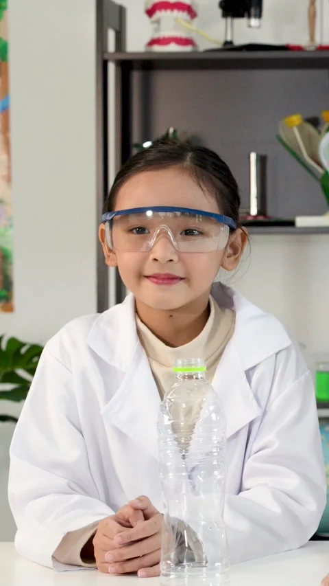 Asian Elementary School Girl in Lab Coat Smiling During Science Class Stock Footage 329277316