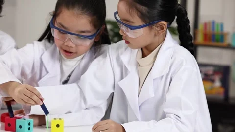 Asian Elementary Students Conducting Magnetism Experiment in Science Lab Stock Footage 341322795