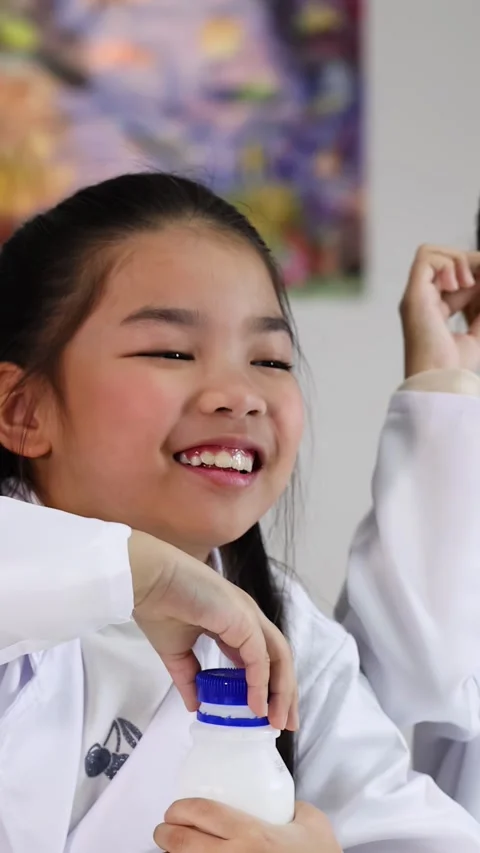 Asian Elementary Students in Lab Coats Conducting Science Experiment Video stock 338060088