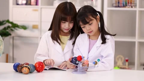 Asian Elementary Students in Lab Coats Studying Solar System Model Stock Footage 342313058
