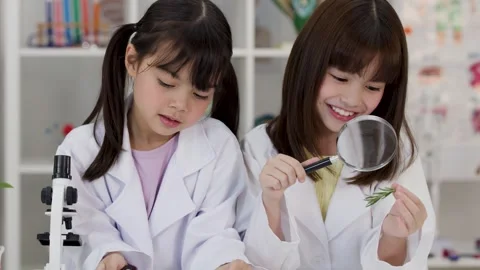 Asian Elementary Students Using Magnifying Glasses in Science Lab Видео 345496675