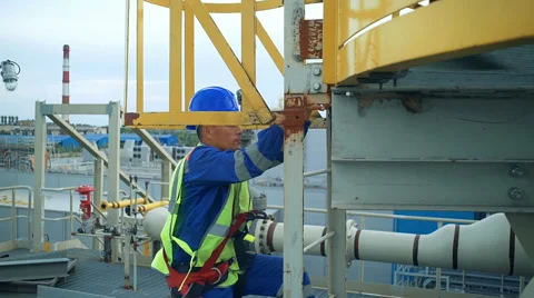 Asian engineer climbing the tower of a large oil refinery Stock Footage