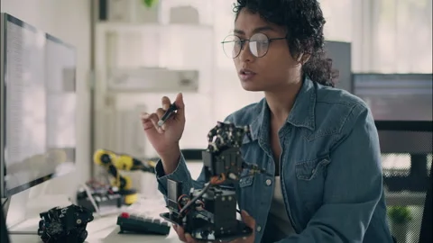 Asian Engineer Examines Robotic Hand Mechanism While Analyzing Code. Stock Footage 307587630