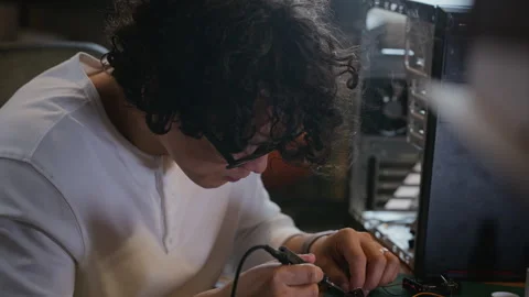 Asian Engineer with Glasses Soldering Microchip on Workdesk Stock Footage 338423470