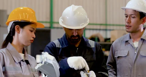 Asian engineer group studies molded component during workshop inspection, Stock Footage 332904481