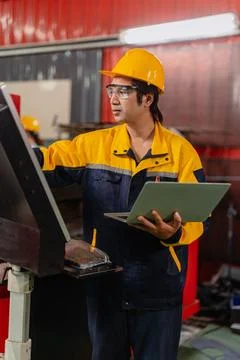 Asian Engineer male worker work control operate machine control panel in me.. Stock Photos