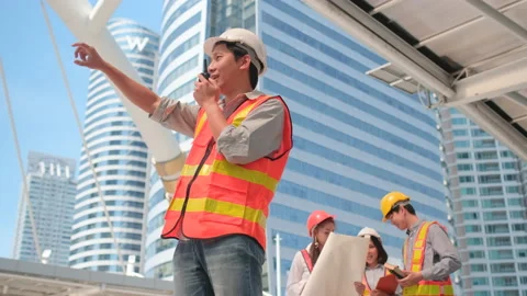 Asian engineer man use walkie-talkie to communicate with other co-worker Stock Footage 143443976