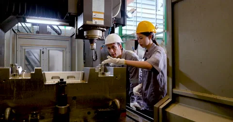 Asian engineer team checks CNC machine interior, guiding fixture setup, tool Stock Footage 337285001