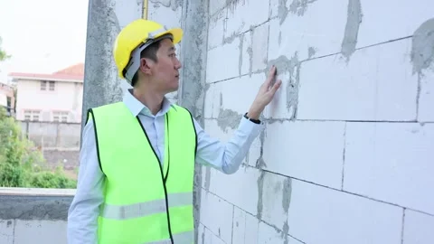 Asian engineer in uniform at construction site while checking and inspecting Stock Footage 241199857