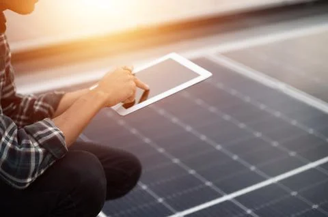 Asian engineer using tablet checking in solar power system for industrial eco Stock Photos