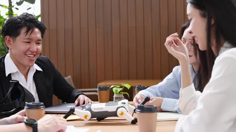 Asian Engineering Students Testing Robotic Dog at Outdoor Cafe Table Stock Footage 347245743
