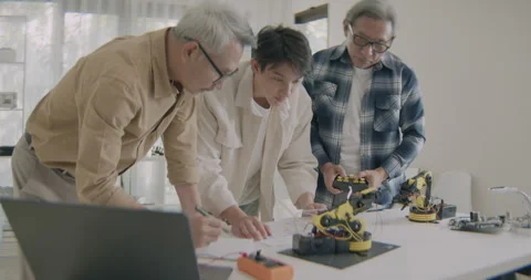 Asian Engineers Working Together On Robotic Arm Innovation Project. Stock Footage 308161099