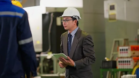 Asian Factory Manager with Tablet Talking to Worker in Plant Stock Footage 343428800