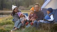 Asian Family On A Camping Trip Relaxing Outside Their Tent Stock Footage