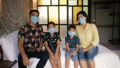Asian family in medical masks during home quarantine. Indonesian or malasian Stock Footage