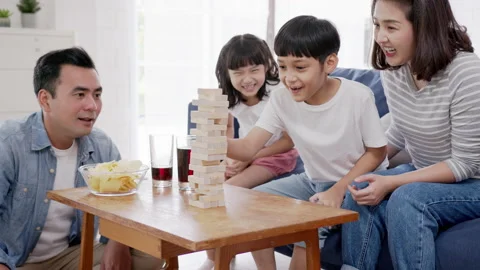 Asian family playing board game with wooden tower together at home. Stock Footage