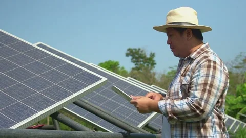Asian farmers use tablets to adjust solar cells degree and check solar cell p Stock Footage 148518573