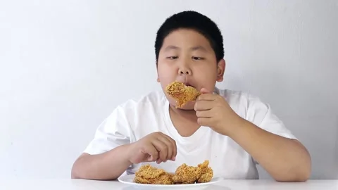 Asian fat boy eats fried chicken Wear a white shirt. Stock Footage 147398316