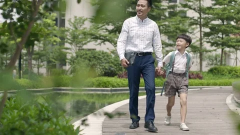 Asian father escorting son going to school in garden slow motion Stock Footage 78201348
