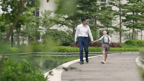 Asian father escorting son going to school in garden slow motion Video stock 78204666