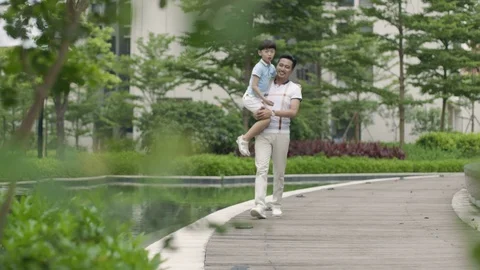 Asian father escorting son going to school in garden slow motion Video stock 78205344